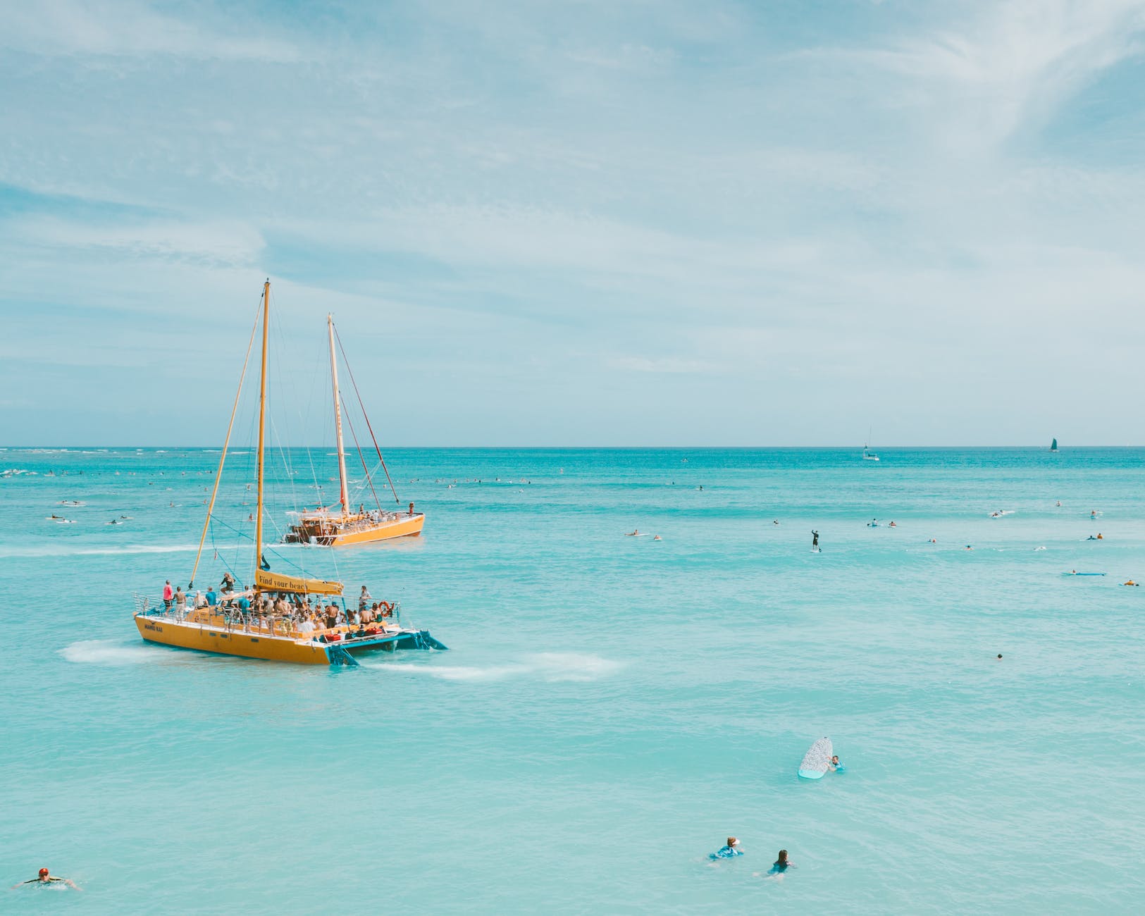 people on white and yellow boat on sea